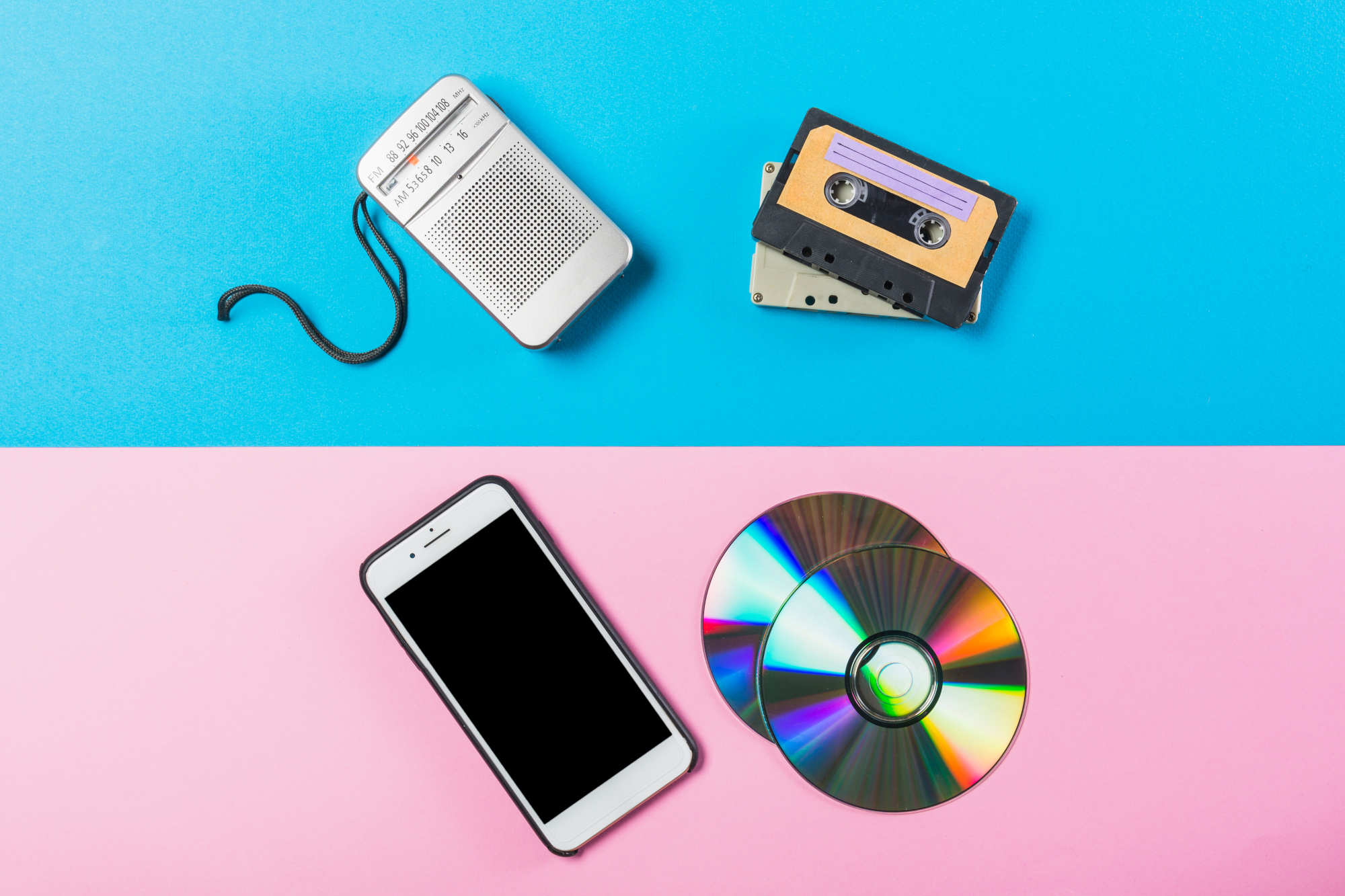 radio cassetta cd e cellulare su doppio sfondo rosa e blu